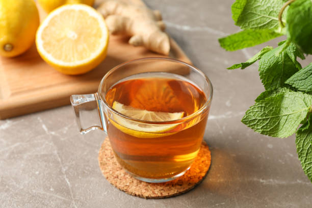 istock Cup of tea, lemon, ginger and mint on grey background, close up 1178930650