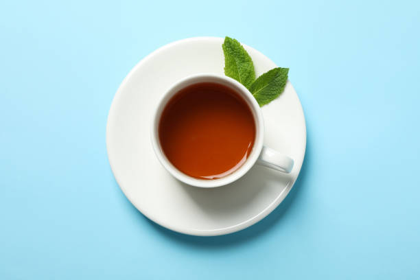 istock Cup of tea and mint leaves on blue background, copy space 1178930685