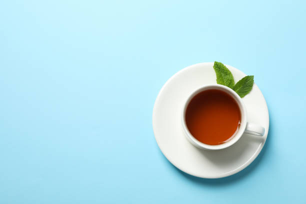 istock Cup of tea and mint leaves on blue background, copy space 1178930696