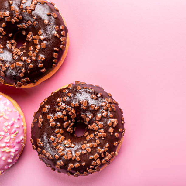 istock Colorful donuts on rose background 1178931128