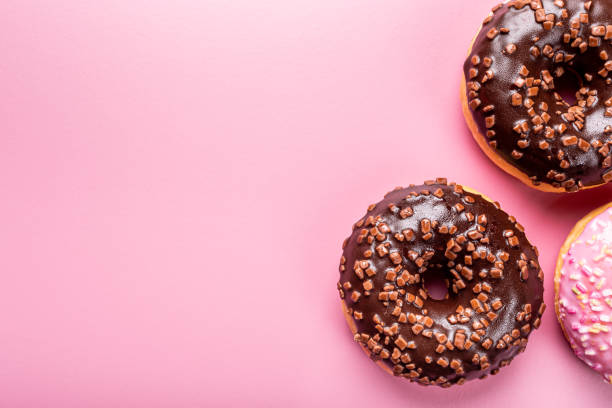 istock Colorful donuts on rose background 1178931129
