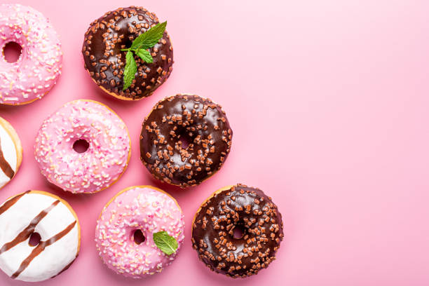 istock Colorful donuts on rose background 1178931130