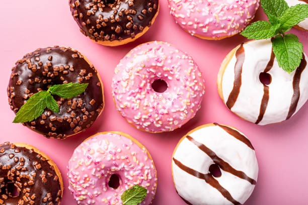 istock Colorful donuts on rose background 1178931137