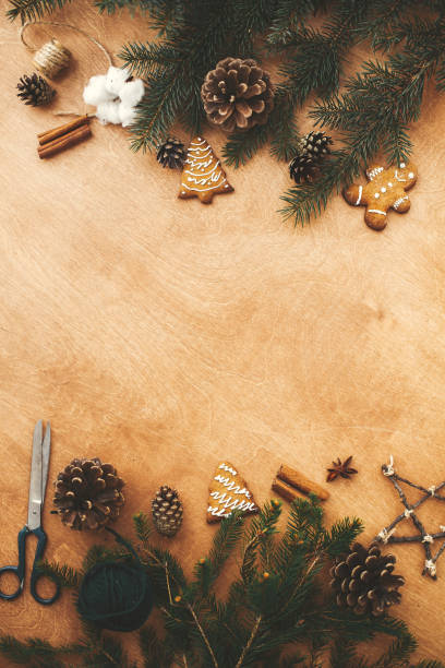 istock Merry Christmas flat lay. Stylish rustic frame of pine branches, cones, gingerbread cookies,thread, cinnamon, anise on rural wooden table. Space text. Seasons greeting card frame mockup 1178931465