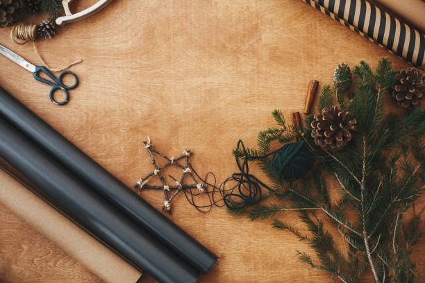 istock Christmas rustic flat lay. Stylish wrapping paper, wooden star, pine branches and cones,  thread on rural wooden table, copy space. Seasons greeting card mockup 1178931483