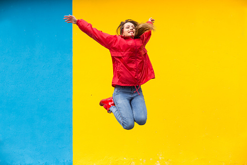 Woman having fun jumping in rainy day