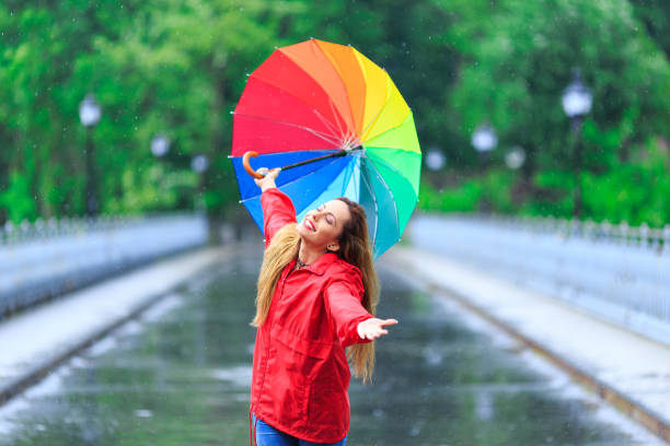 istock Woman with colorful umbrella having fun in rainy day 1178932007