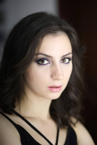 Beautiful girl doing makeup in front of a mirror
