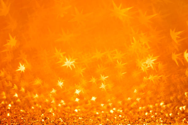 Golden Christmas background - defocused bokeh with star shape. Space for copy. It's a real bokeh photo, not an illustration or computer filter.