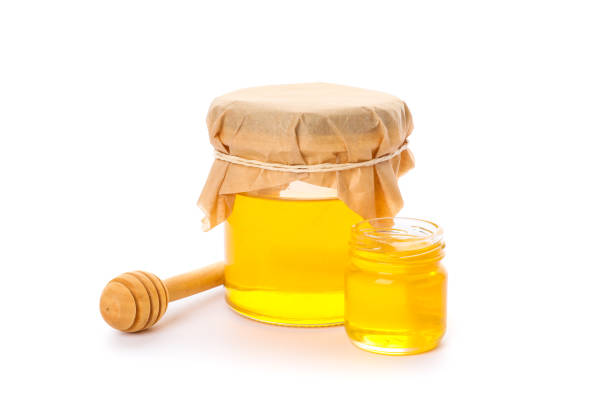 istock Dipper and glass jars with honey isolated on white background 1178942013
