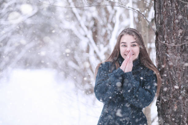 istock Girl in a winter park in snowfall 1178943719