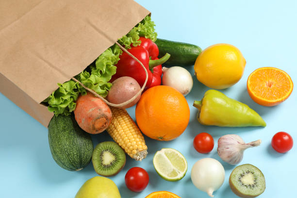 istock Paper bag, vegetables and fruits on blue background, space for text 1178944883