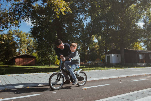 istock Father Learning his son to ride a bicycle 1178949874
