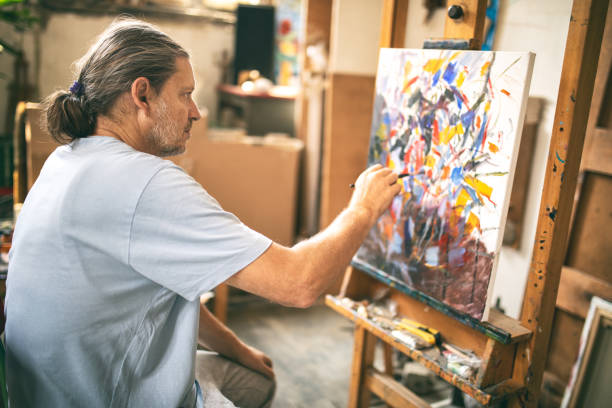 istock Mature man working and painting in art studio 1178952325