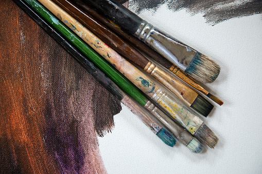 Group of brushes on painted canvas image