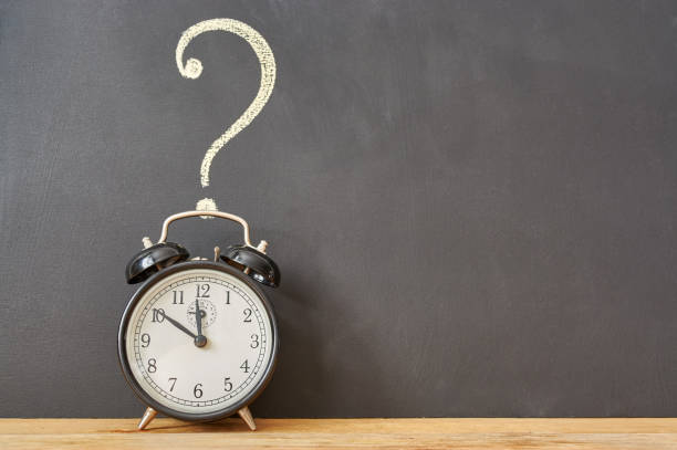 istock alarm clock on a background of a chalk drawn question on a chalkboard. copy space 1178960148