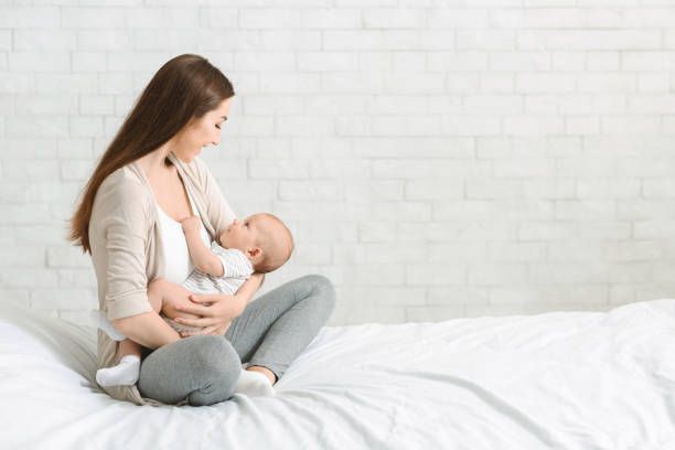 istock Young smiling mom nursing her newborn child 1178960184