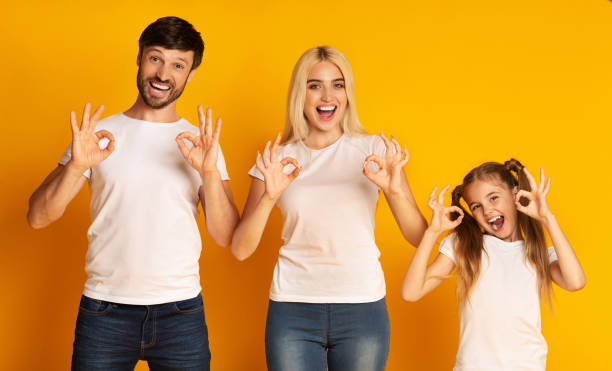 Cheerful Family Gesturing Okay Standing Over Yellow Background, Studio Shot OK. Cheerful Family Gesturing Okay With Both Hands Standing Over Yellow Background. Studio Shot ok sign photos stock pictures, royalty-free photos & images