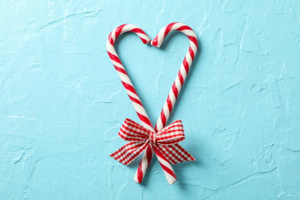 istock Sweet candy canes with bows on blue background, space for text 1178962791