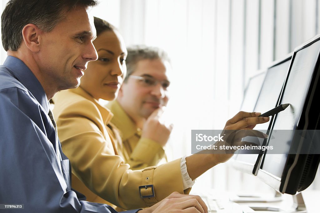 Business People Looking at Computer Monitor Group of businessmen and businesswomen. Horizontal shot. Adult Stock Photo