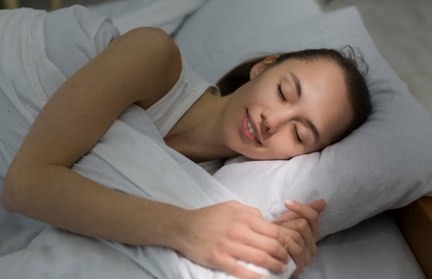istock Girl sleeping in bed, morning sunbeam falling on face 1178963222