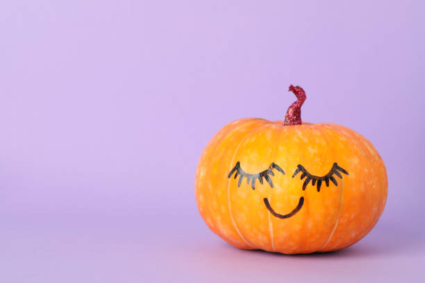 istock Pumpkin with smile on violet background, space for text 1178964390