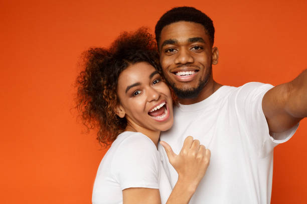 istock Positive african american couple hugging and taking selfie 1178964585