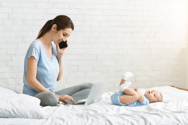 istock Young woman combining work at home with child care 1178964638