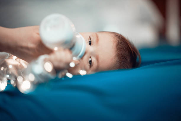 Baby girl laying on her back, drinking from baby bottle