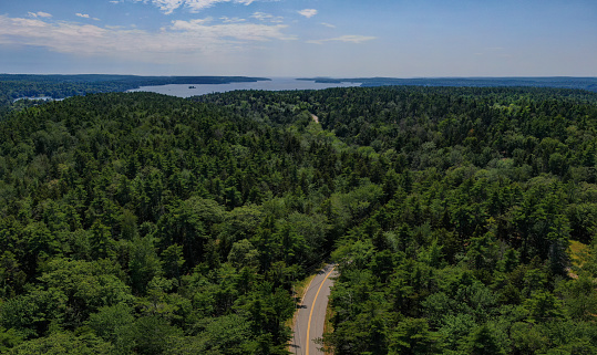 Aerial shot of the winding roads and impervious woods along the coastline of Maine,USA.