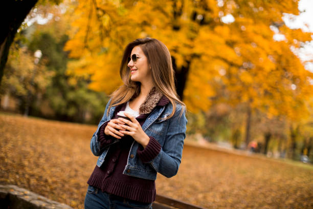 istock Woman drinking coffee in autumn park 1178966451