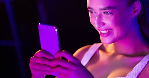 istock Girl surfing internet on phone in pink neon light 1178966596