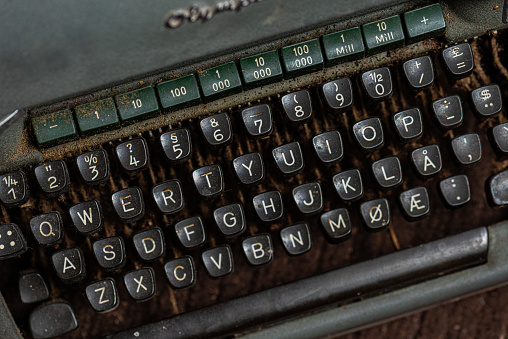 Carriage block with letters in an old mechanical typewriter. Close-up, open aperture.