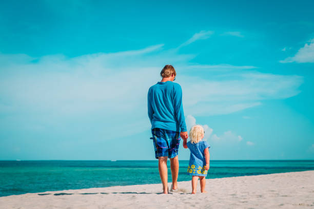 istock father and little daughter walk on beach 1178970746