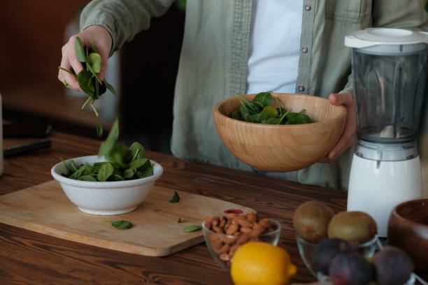 istock Girl pours spinach leaves in a plate 1178971014