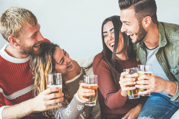 istock Group of happy friends cheering with beer at home - Millennial Young people having fun drinking and laughing together sitting on sofa - Friendship, entertainment and youth lifestyle holidays 1178972705