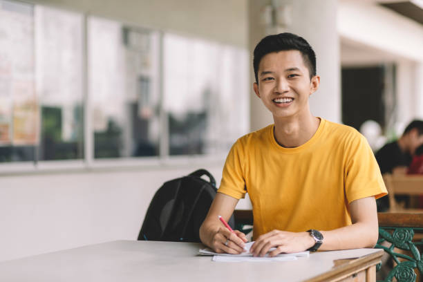istock an Asian Chinese university student sitting at the table looking at the camera 1178974402