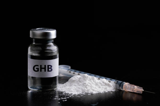 бутылка ghb со шприцем на черном фоне. опасные женщины наркотиков - drug abuse narcotic medicine protection стоковые фото и изображения