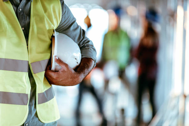 istock Architect worker holding white helmet a for workers security control at city site 1178984304