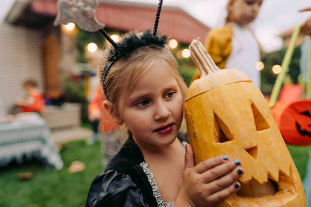 istock Cute little girl holding a Jack O' Lantern 1178984431
