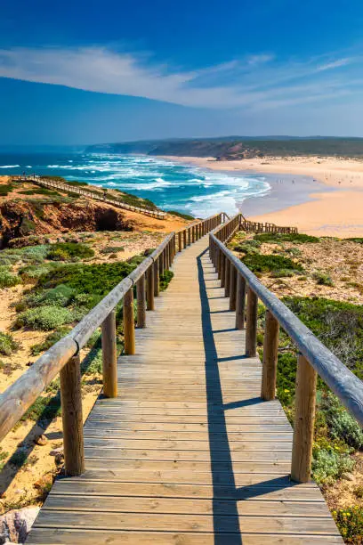 Photo of Praia da Bordeira and boardwalks forming part of the trail of tides or Pontal da Carrapateira walk in Portugal. Amazing view of the Praia da Bordeira in portuguese. Bordeira, Algarve, Portugal.