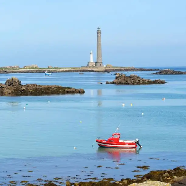 Photo of View of Île Vierge lighthouse, several boats and the sea coast in Brittany, France