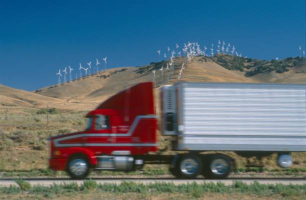 California, USA, 1987. Highway with passing truck. In the background wind wheels.