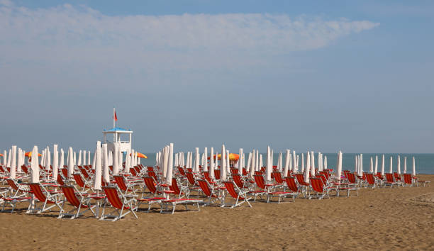 istock Red deck chairs and clodes umbrellas sun on the beach 1178996237