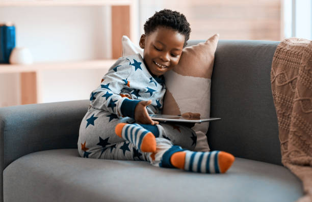 These apps make sure I never get bored Full length shot of an adorable little boy using a digital tablet while relaxing on a sofa at home never stock pictures, royalty-free photos & images