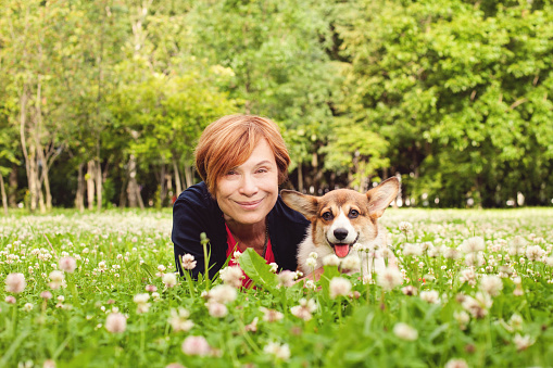 Beautiful senior woman with dog in spring nature