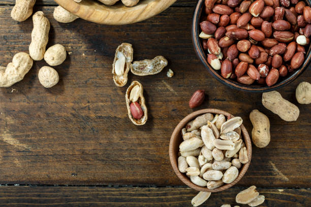 istock Inshell peanuts are scattered on the table. next is a plate with peeled peanuts. 1179000161