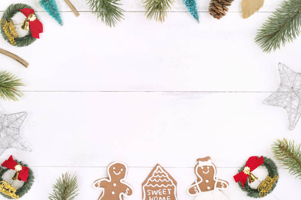 istock Christmas concept composition decoration objects, fir tree branch wreath, gingerbread man biscuit isolated on white wooden table. 1179004081