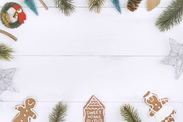 istock Christmas concept composition decoration objects, fir tree branch wreath, gingerbread man biscuit isolated on white wooden table. 1179004095
