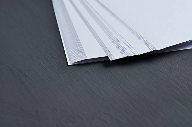 istock One scattered heap of empty white paper sheets lies on dark concrete table on workplace of secretary, director, boss or other worker of company. Space for text 1179005609